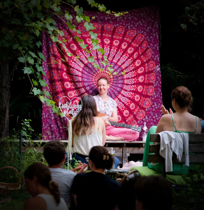 Konzert im Freien, Helena vor buntem Tuch, Menschen im Vordergrund